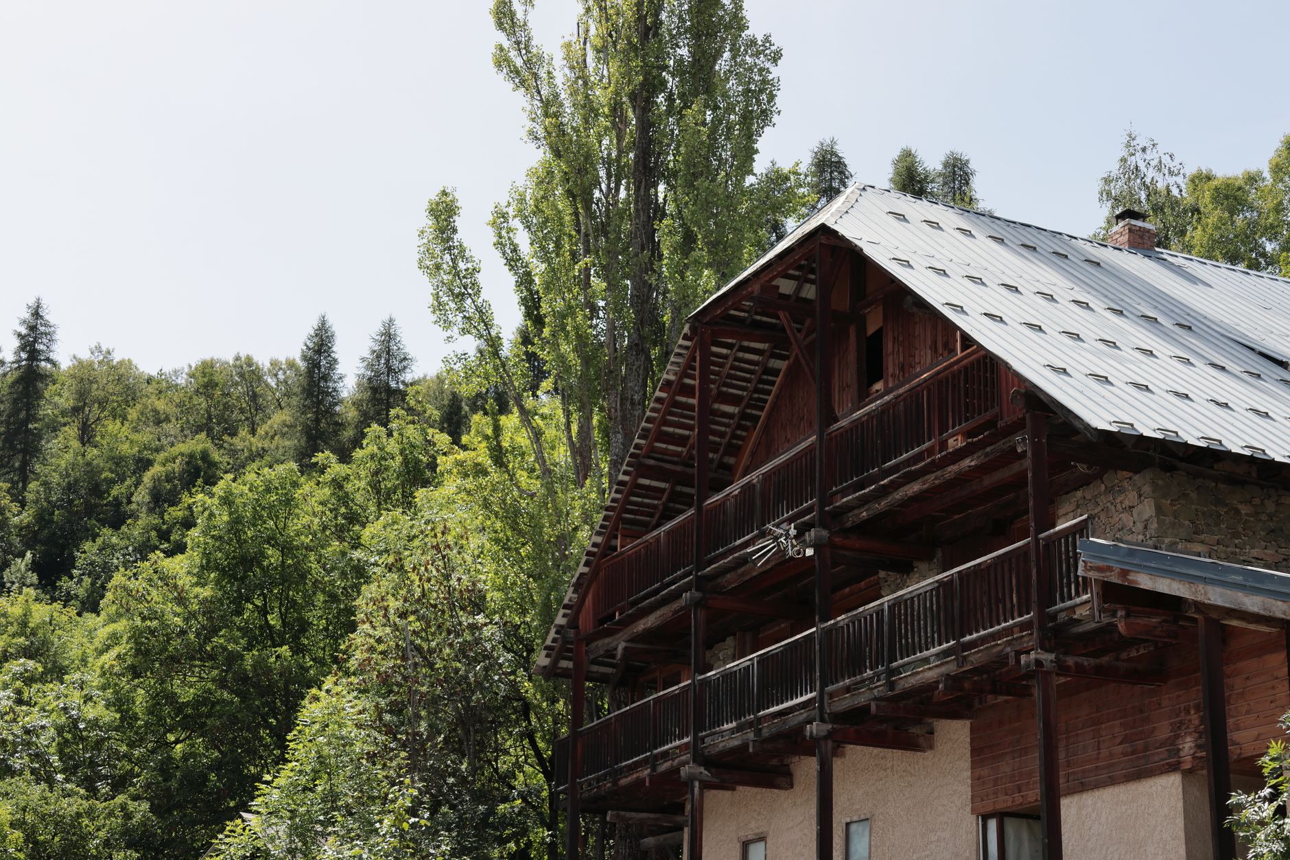 Rustic chalet with wooden balconies nestled in a lush forest in Puy-Saint-Vincent, France. — photograph by César Guillotel on Pexels
